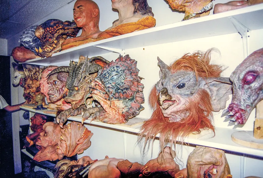 Studio shelves packed with dragon, gargoyle, zombie, and animal-like creature heads and busts.