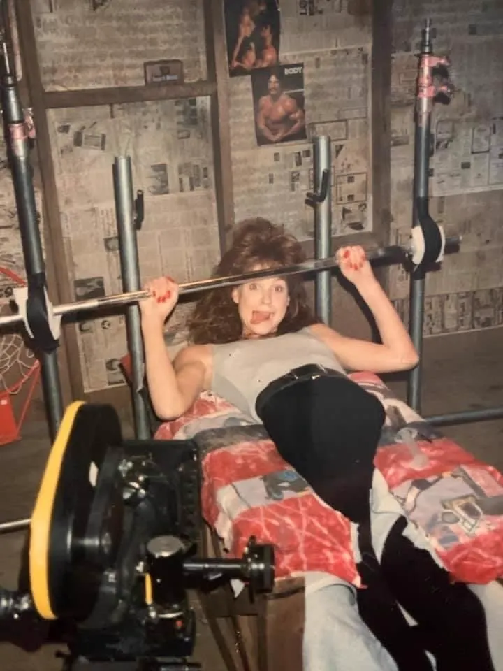 Brooke Theiss poses on the weight-bench set used for Debbie's transformation in A Nightmare on Elm Street 4.