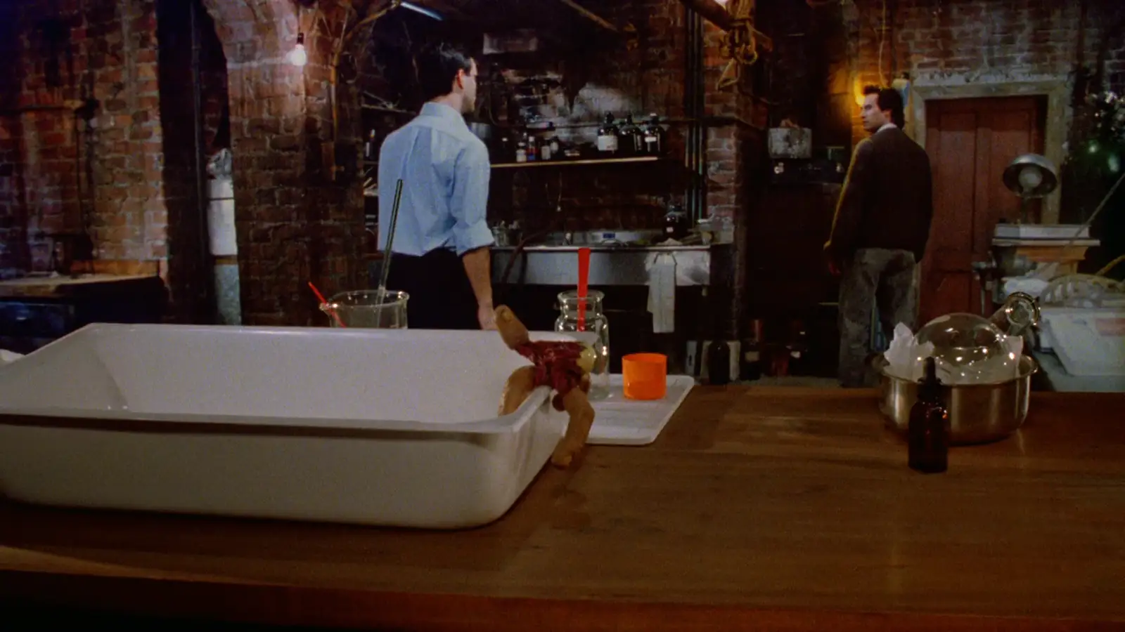 The lab bench — the finger-eyeball creature crossing the table